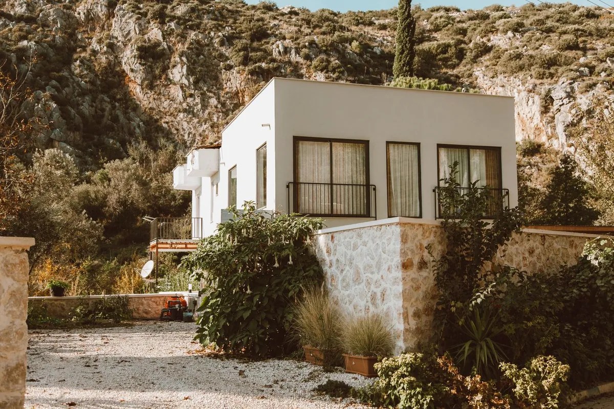 A sunlit home set against a rocky landscape