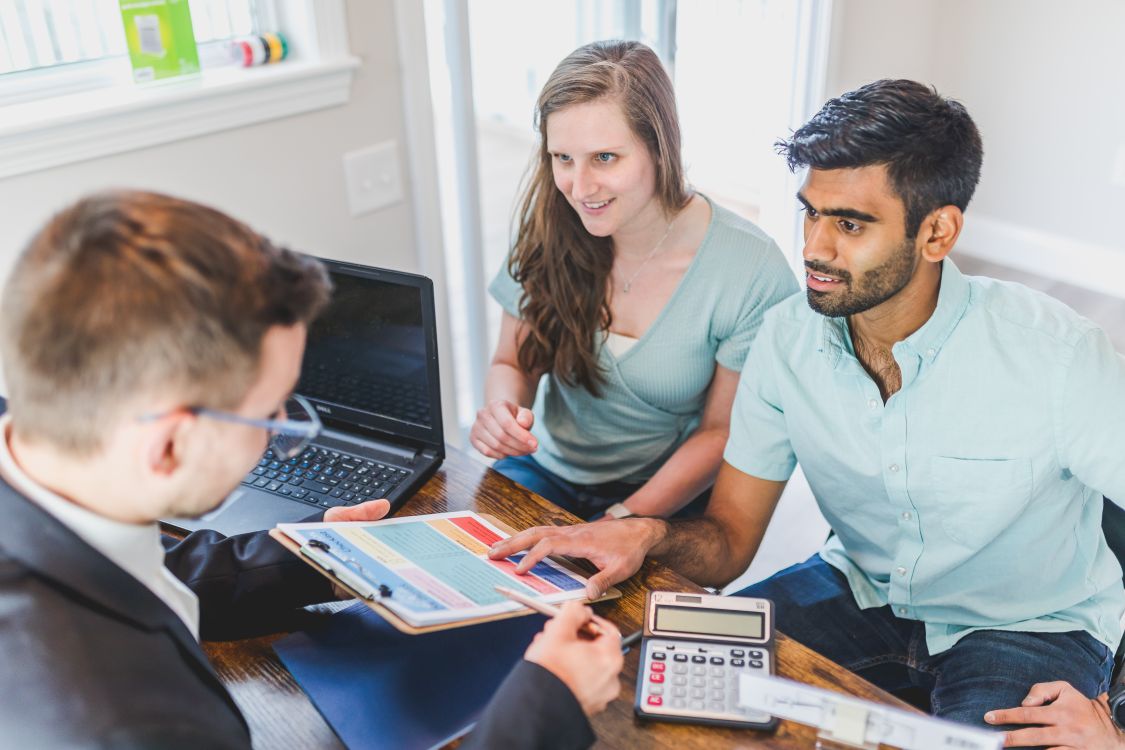 A couple reviewing documents with an adviser at a table